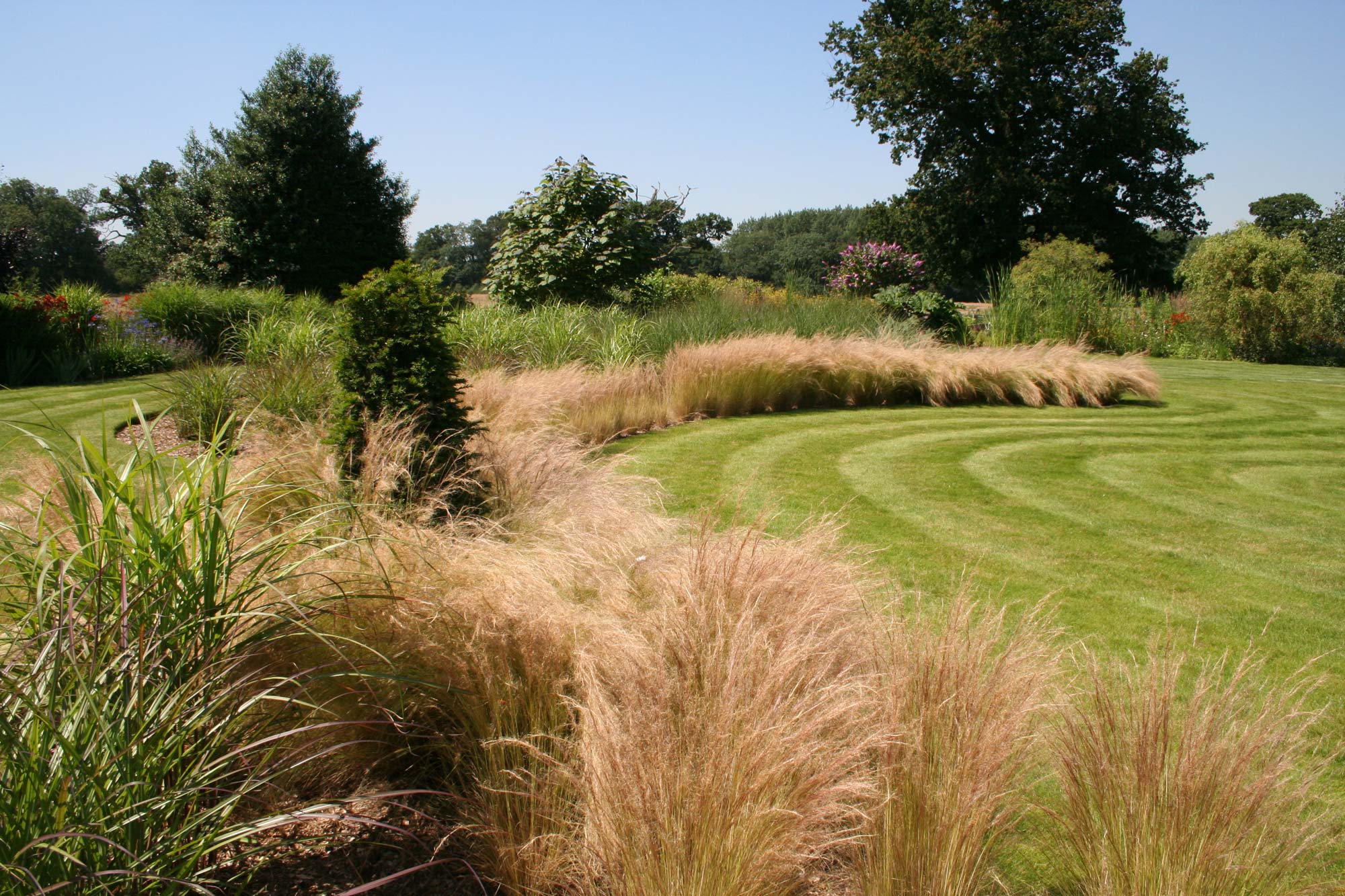 Garden of spiral grass borders designed by Peter Eustance  Planted border