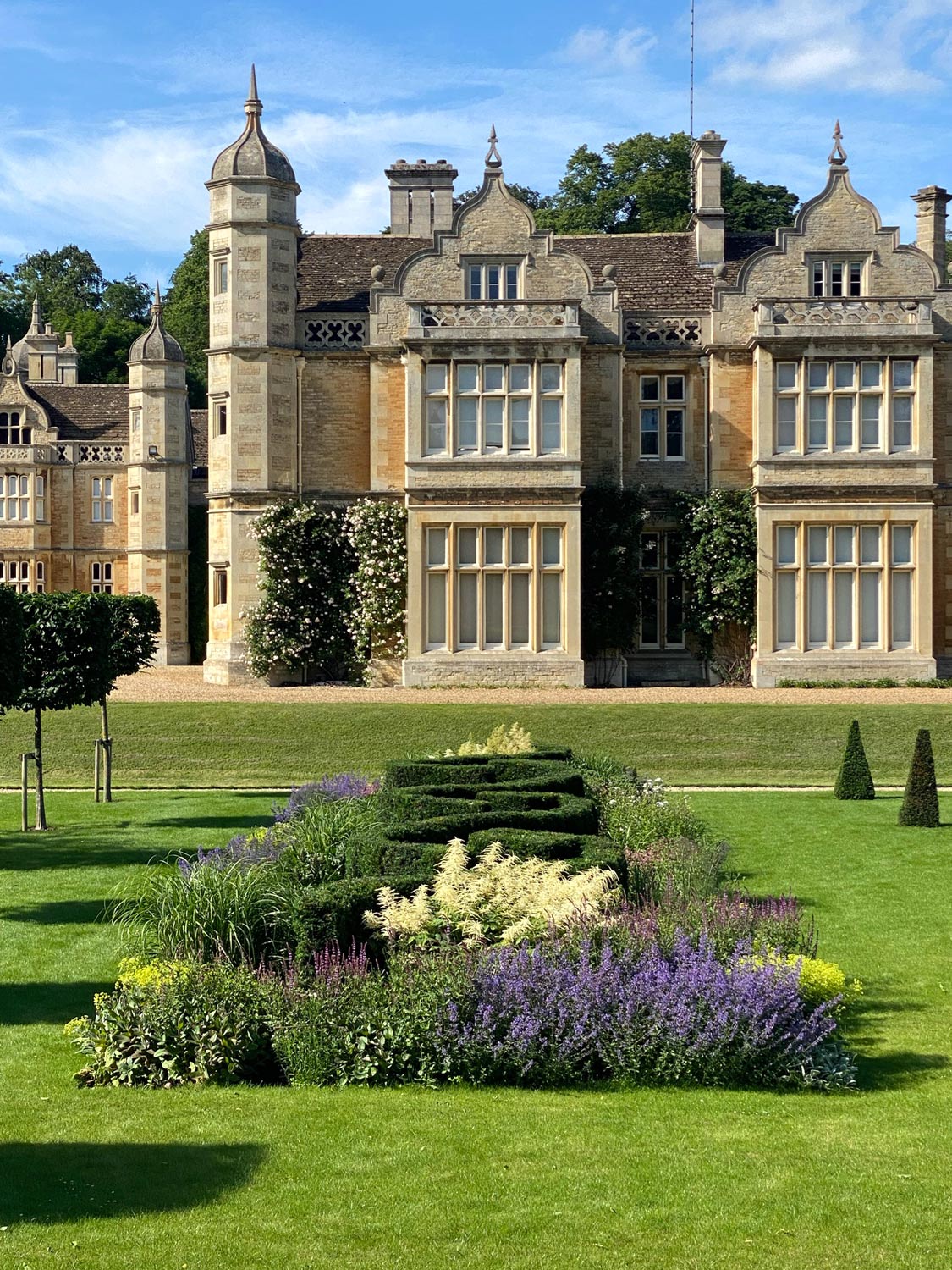 Exton Hall view to west gables across new planted border and with plaited yew hedge designed by Peter Eustance